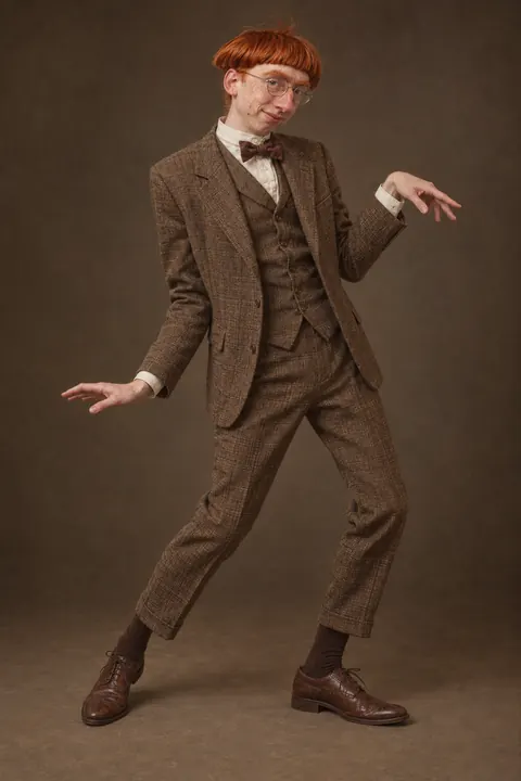 milton bumford mid-dance in a full tweed suit, arms out, one knee bent